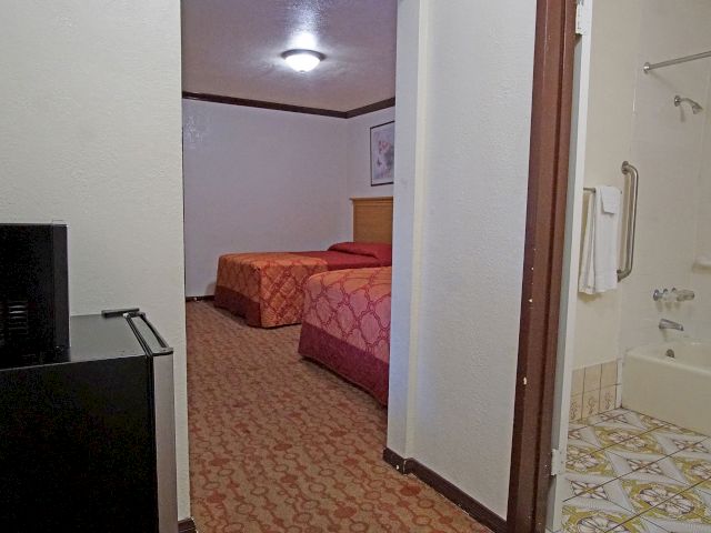 A hotel room with two beds and a bathroom