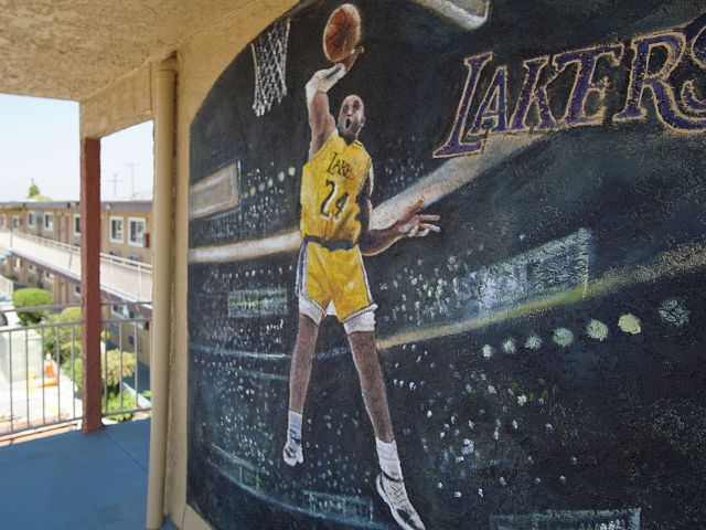 A mural of a basketball player in a yellow jersey on a wall