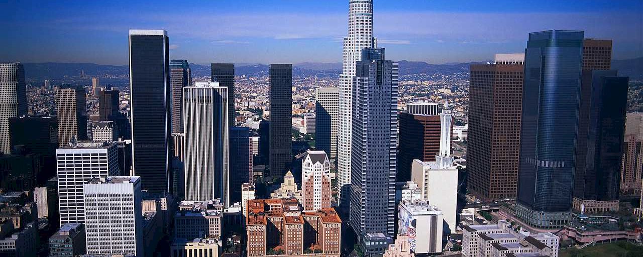 A cityscape with many skyscrapers and mountains in the background.