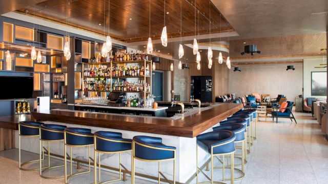 A bar with a long counter and several high chairs.